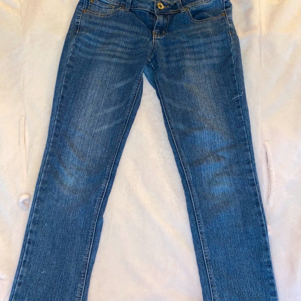 Blue denim jeans with sheer rip at bottom